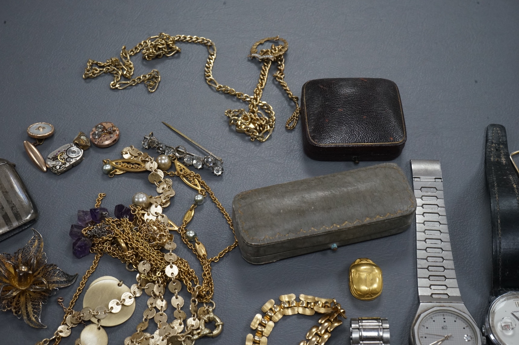 A quantity of assorted costume jewellery and other items including wrist watches, watch movements and a silver vesta case.